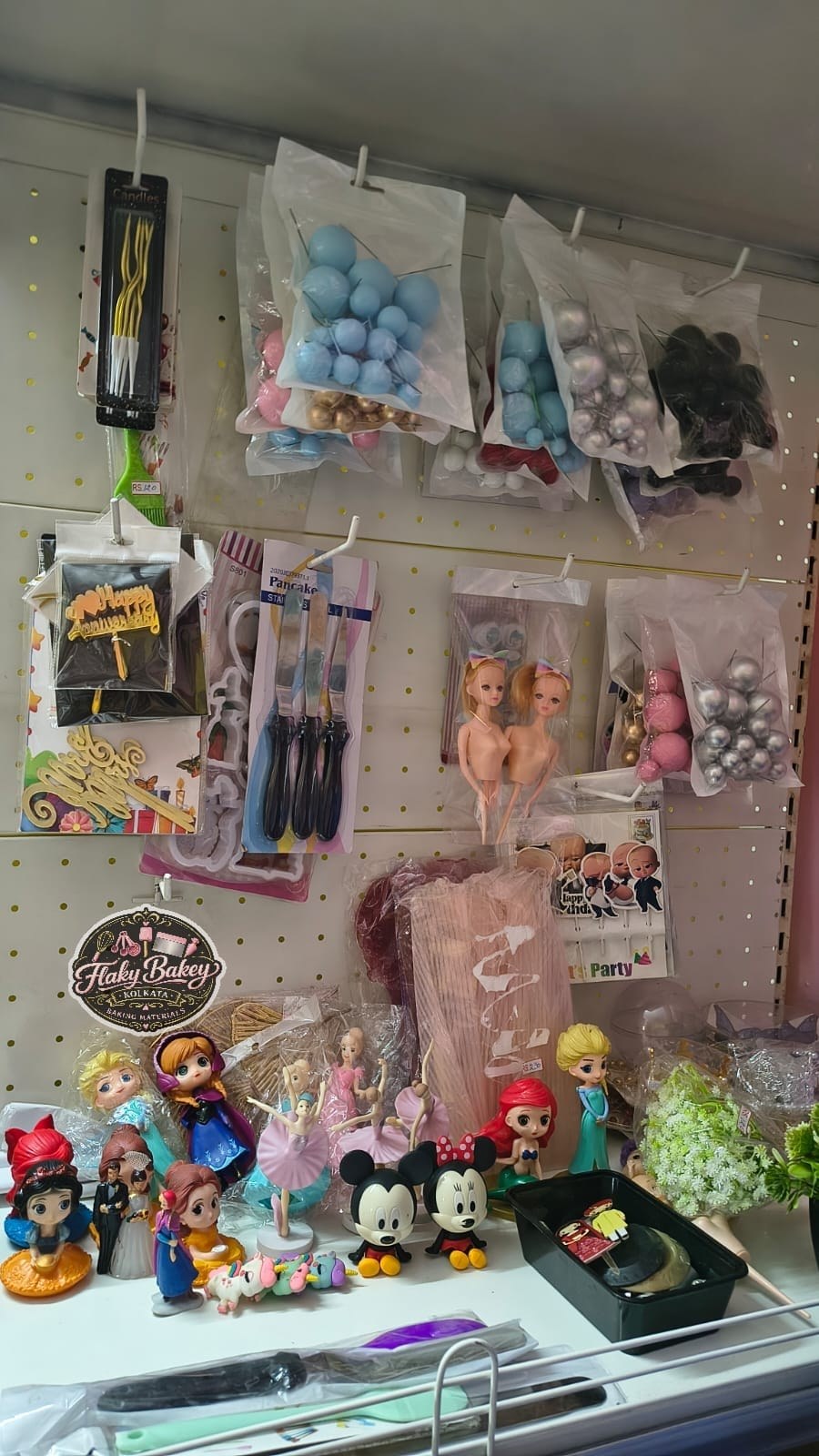 Flaky Bakey baking materials store shelf — cake toppers and decorating supplies, Hatiara Kolkata